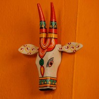  White and orange handpainted cow face wall decor featuring vibrant traditional Indian folk art patterns.