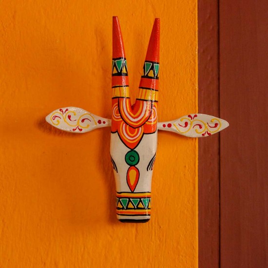  White and orange handpainted cow face wall decor featuring vibrant traditional Indian folk art patterns.