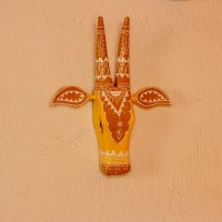 White base cow face wall decor with yellow and brown handpainted detailing in traditional Indian folk art style.
