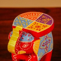 Small handpainted red elephant figurine with vibrant traditional patterns, crafted in Indian folk art style.
