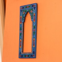 Hand Painted Floral Arch Frame – Blue, Front View Front view of a tall wooden arch-shaped frame hand painted in bright blue, with floral borders in pink, red, yellow and green and an open arched centre.