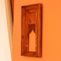 Hand Carved Wooden Arch Frame – Front View Front view of a tall rectangular wooden frame hand carved all over in an antique natural finish, with a leaf-patterned border and an arched opening below a carved panel.