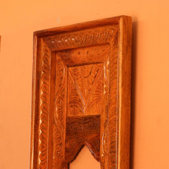 Hand Carved Wooden Arch Frame – Front View Front view of a tall rectangular wooden frame hand carved all over in an antique natural finish, with a leaf-patterned border and an arched opening below a carved panel.