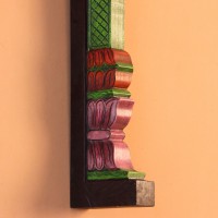 Hand Painted Pillar Wall Bracket Styled on Wall Extreme close-up of the carved petal-shaped bands in pink, red and purple, with ridged layers and painted green edging.