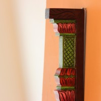 Hand Painted Pillar Wall Bracket Styled on Wall Extreme close-up of the carved petal-shaped bands in pink, red and purple, with ridged layers and painted green edging.