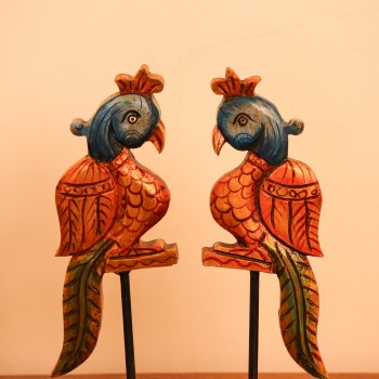 Handcrafted Bird Table Decor on Iron Stand Artistic wooden bird figurine mounted on an iron stand with handcrafted detailing and vibrant ethnic-inspired colors.