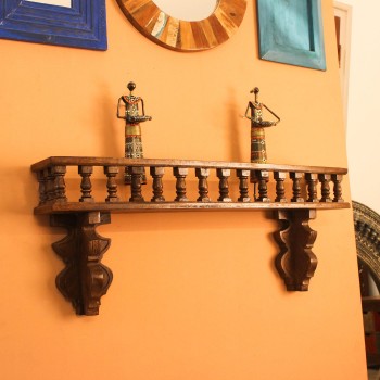 Handcrafted dark polish wooden wall shelf with turned spindle detailing and carved apron, a vintage Indian heritage decor piece.