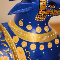 Blue Nandi Figurine with Golden Finish Styled on Table Cobalt blue wooden Nandi figurine with gold painted detailing placed on a wooden table as a pooja or console accent.