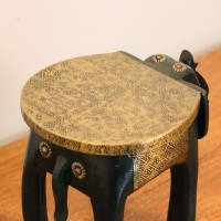 Elephant Stool – Green with Embossed Brass, Side View Side view of the elephant stool, showing the raised trunk, the brass-embossed seat and the brass side panel set between the dark green legs.