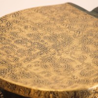 Elephant Stool – Green with Embossed Brass, Side View Side view of the elephant stool, showing the raised trunk, the brass-embossed seat and the brass side panel set between the dark green legs.