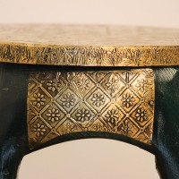 Elephant Stool – Green with Embossed Brass, Side View Side view of the elephant stool, showing the raised trunk, the brass-embossed seat and the brass side panel set between the dark green legs.