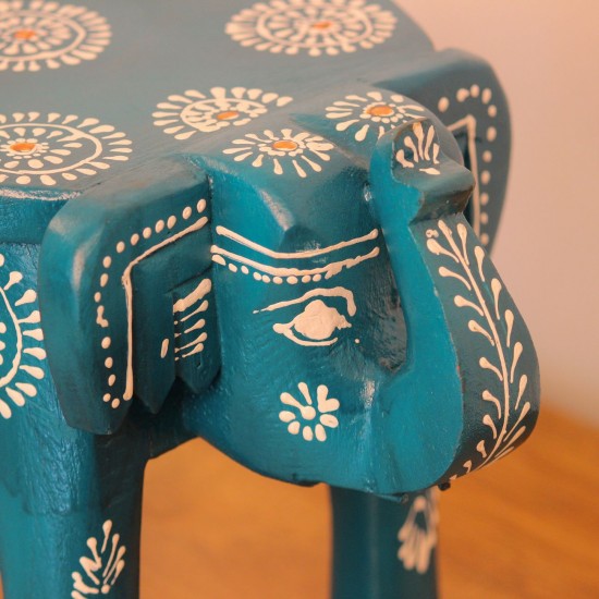 Teal blue hand-painted wooden elephant stool placed on a wooden table as a side stool or display stand.
