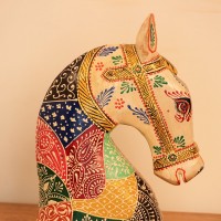 Hand Painted Folk Motif Horse Head Decor Styled on Table Hand-painted folk motif wooden horse head with a cream face placed on a wooden table as a colourful tabletop accent.