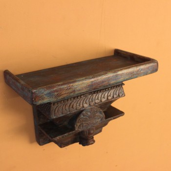 Distressed Blue Carved Wooden Wall Shelf – Styled on Wall Distressed blue carved wooden shelf mounted on a warm wall with a décor piece on top