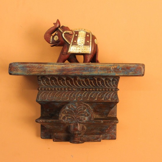 Distressed Blue Carved Wooden Wall Shelf – Styled on Wall Distressed blue carved wooden shelf mounted on a warm wall with a décor piece on top