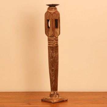 Candle stand crafted from a repurposed antique bed leg, turned into a slender pillar form with a whitewashed distressed finish and a black metal candle plate on top.
