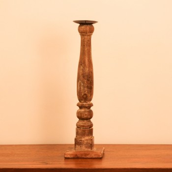 Candle stand crafted from a repurposed antique bed leg, turned into a compact pillar form with a natural wood finish and a black metal candle plate on top.