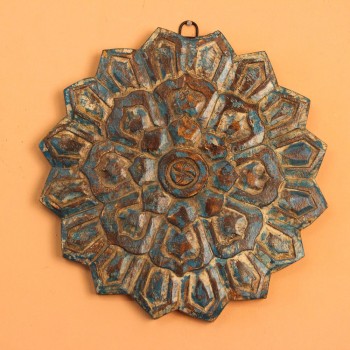 Genuine antique wooden medallion carved in a radiating star-shaped mandala pattern, showing traces of original blue and brown pigment across its surface.