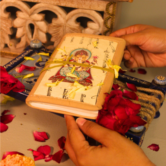 Calligraphy Bahi Khata Journal Ganesha Ji Handmade Ganesha Bahi Khata diary placed near pooja setup with marigold flowers and diya