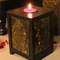 Antique Brass Ganesha Tealight Stand (Candle Holder) Antique brass Ganesha tealight stand featuring a seated Ganesha carving on a square wooden base with intricate brass panels — traditional Indian décor for pooja and living room ambiance.
