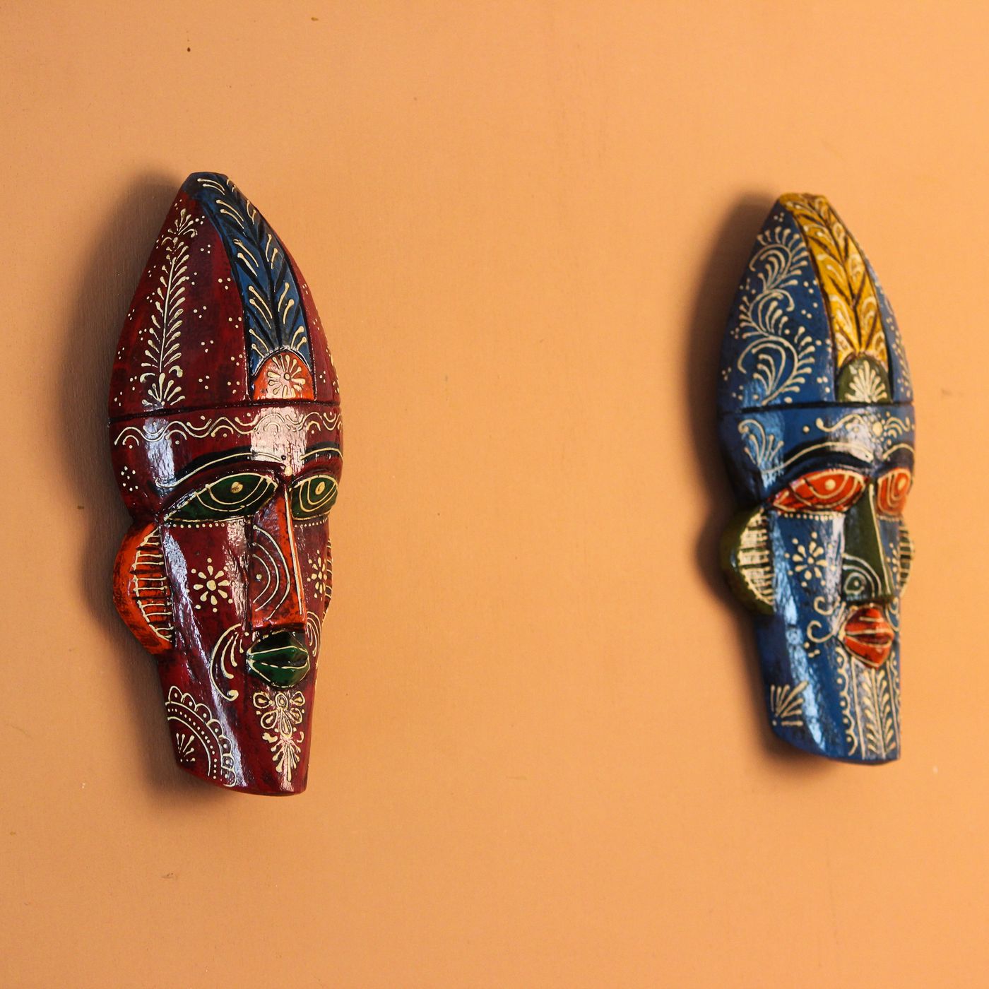 Pair of hand-painted wooden tribal masks in blue and maroon, wall hanging by INDUNE